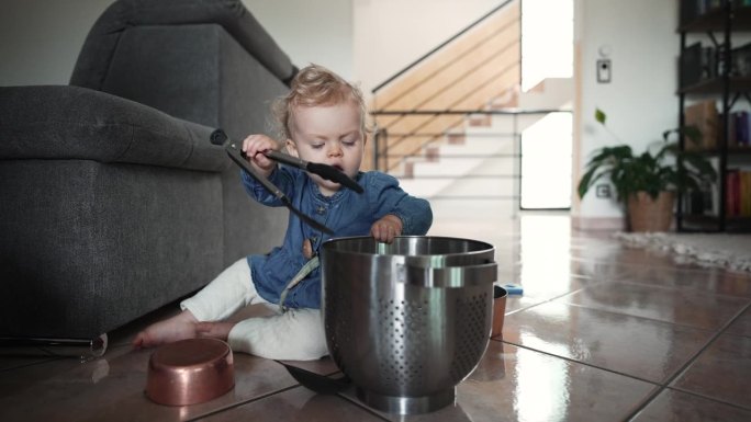 女婴在家里玩锅碗瓢盆