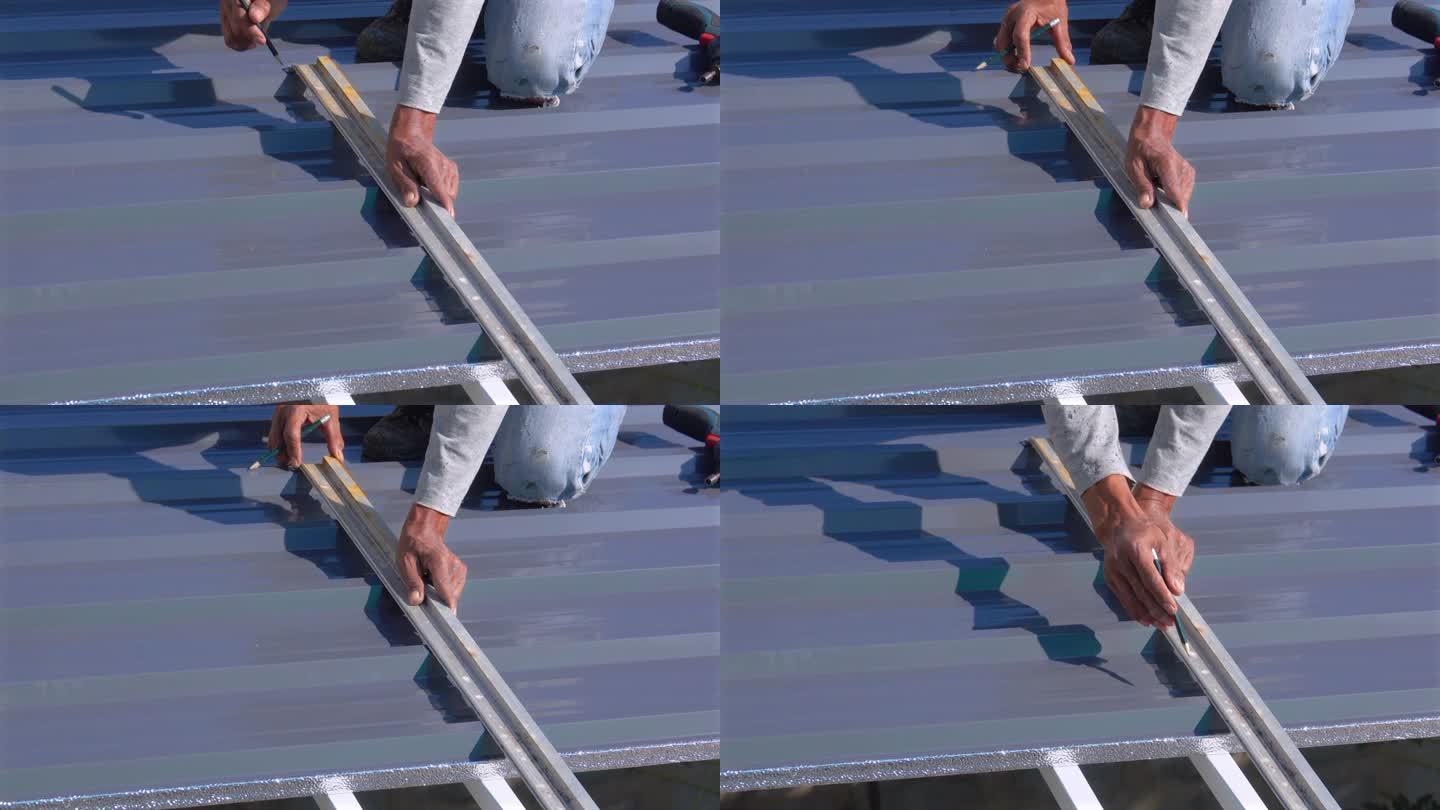 工人在屋顶上用铅笔做记号