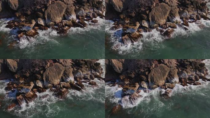 从空中俯瞰，大海撞击着海边的岩石。海泡石。日落时到达海岸的海浪。4K无人机视频