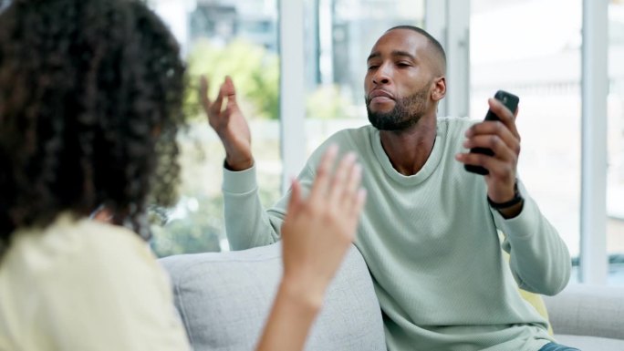 夫妻，在家里用电话欺骗和争吵，在沙发上打架或争执。种族间，离婚事件和愤怒的黑人男女冲突，沮丧或婚姻问
