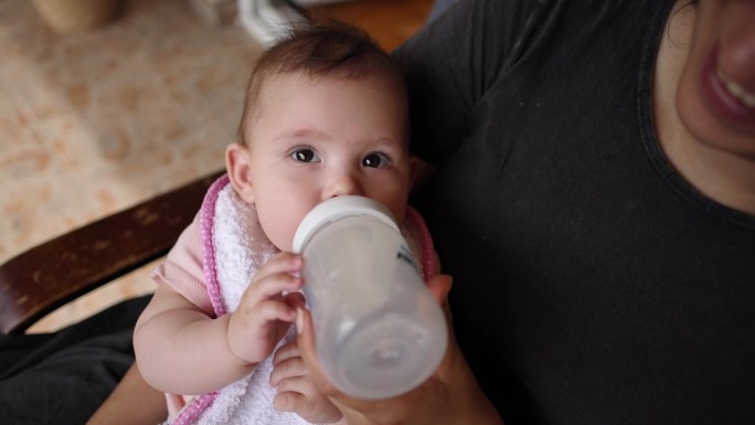 B-roll的用法和样例:母亲用婴儿杯里的牛奶喂她的女婴