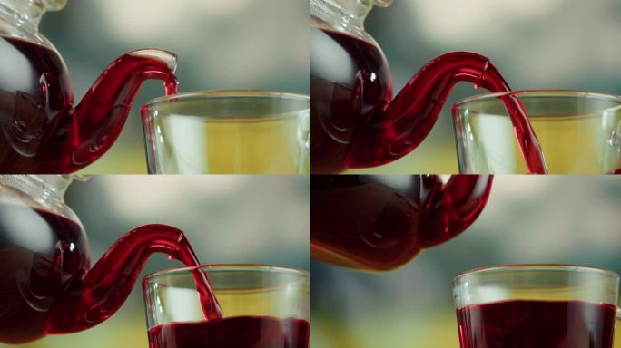 将红果茶倒入玻璃杯(特写)。现泡木槿茶道工艺，健康早晨，排毒饮品。