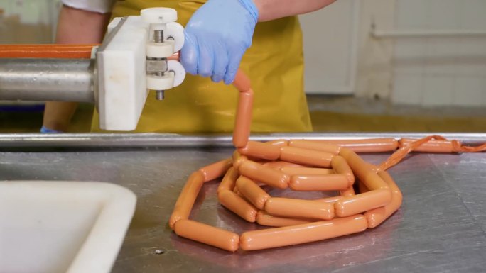 肉店的女屠夫正在处理用塑料薄膜包装的香肠。