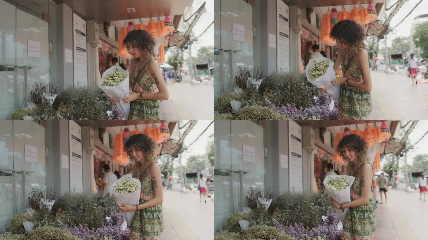 女游客在曼谷旅游时，在花市挑选鲜花。