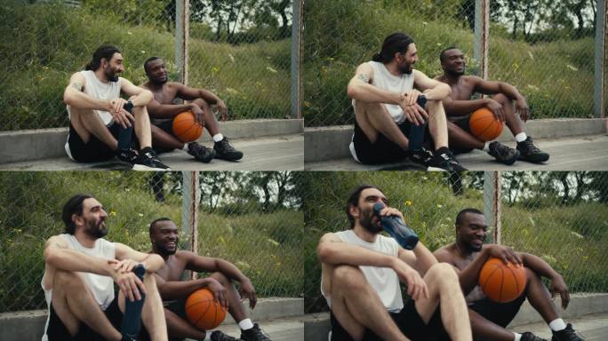 两个男人坐在篮球场的地板上，聊着正在进行的比赛，他们很高兴能参加比赛