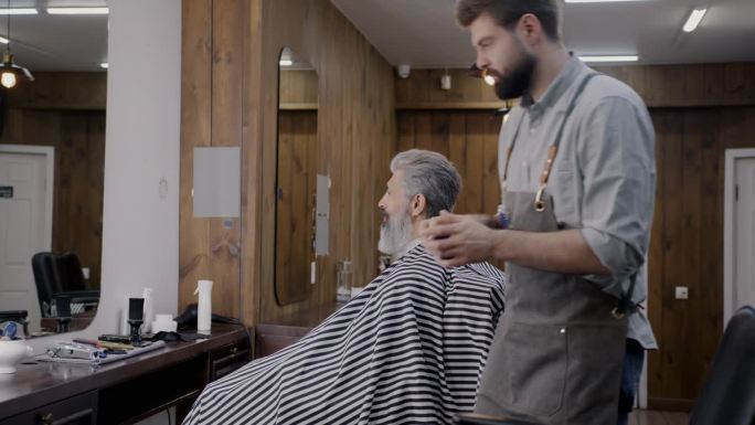 专业理发师打开罐子，在头发上涂抹化妆品，为客户提供理发店的护理