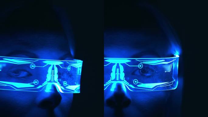 黑暗中一个戴着未来主义眼镜的女人的近景。慢动作