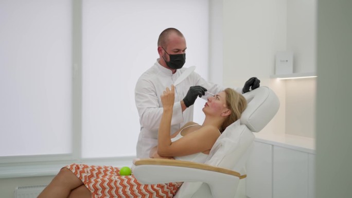 一位美容师正在给一位年轻女士注射肉毒杆菌
