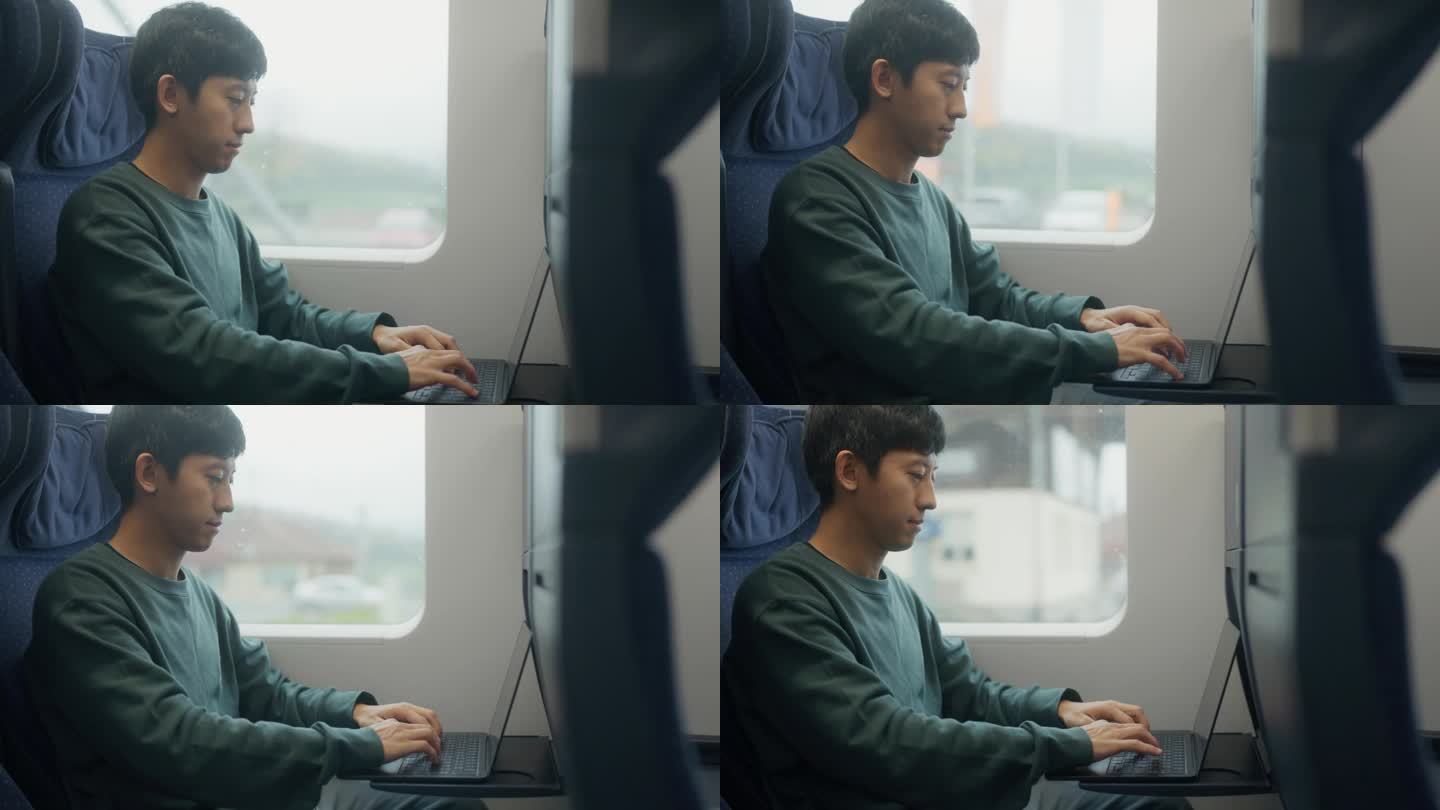 一位亚洲企业家坐在火车上的笔记本电脑窗口边，准备去旅游。