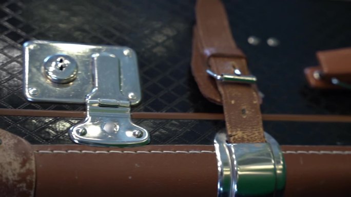 一个带有皮带和带扣的老式皮箱的特写