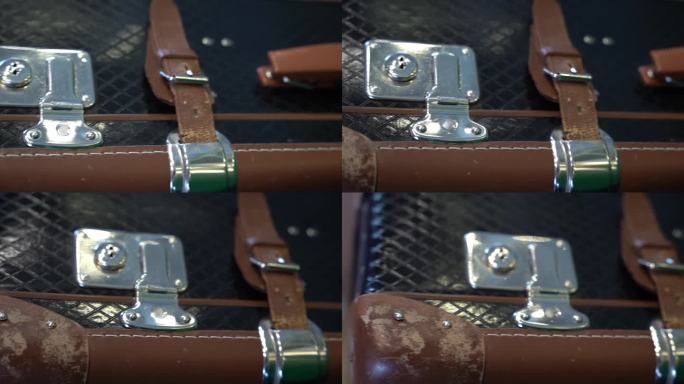 一个带有皮带和带扣的老式皮箱的特写