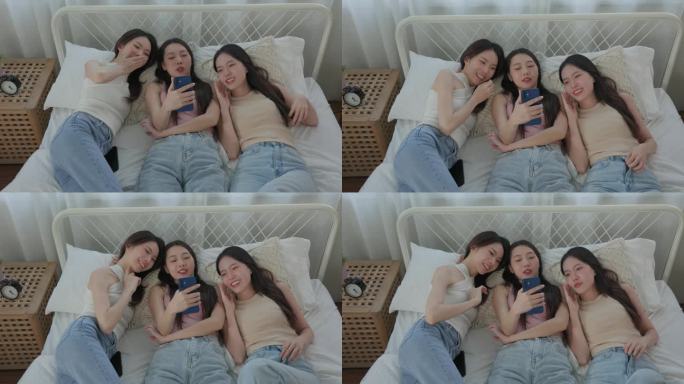 年轻亚洲女性的谈话。躺在床上看智能手机