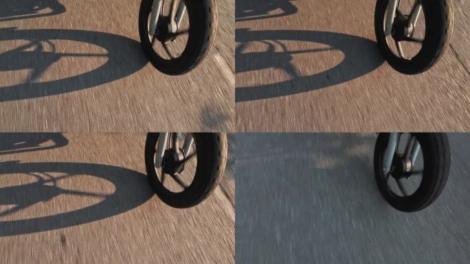 摩托车车轮在日落与阴影投射在道路上的细节