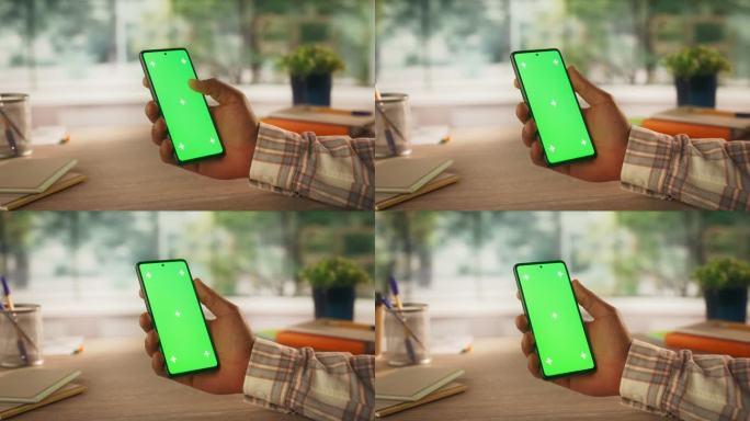 匿名黑人使用智能手机模拟绿屏Chromakey显示与运动跟踪占位符。经理在线浏览应用界面，在手机上滑