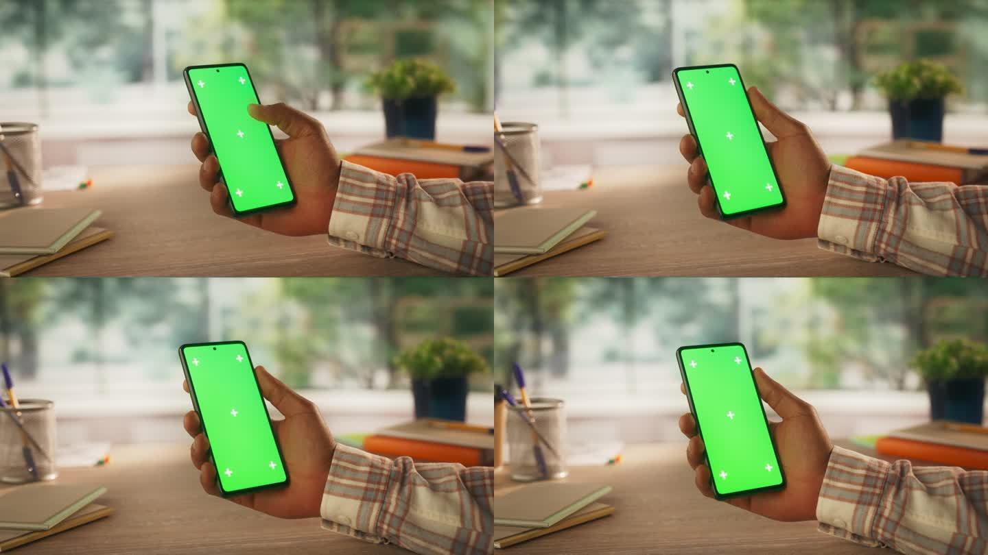 匿名黑人使用智能手机模拟绿屏Chromakey显示与运动跟踪占位符。经理在线浏览应用界面，在手机上滑