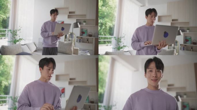 一个在家里用笔记本电脑的韩国帅哥的肖像。穿着休闲服的亚洲男子从沙发上站起来，发送电子邮件，微笑着看着