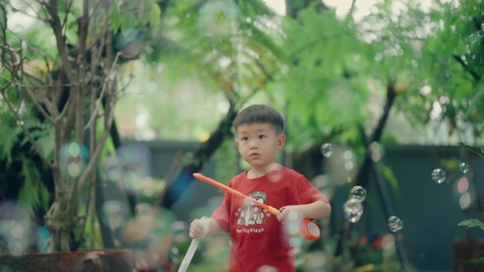 充满活力的快乐的亚洲孩子专注于吹肥皂泡:顽皮的天真释放