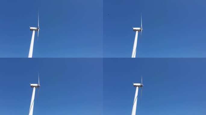 风力涡轮机的转子在蓝天的映衬下快速旋转。