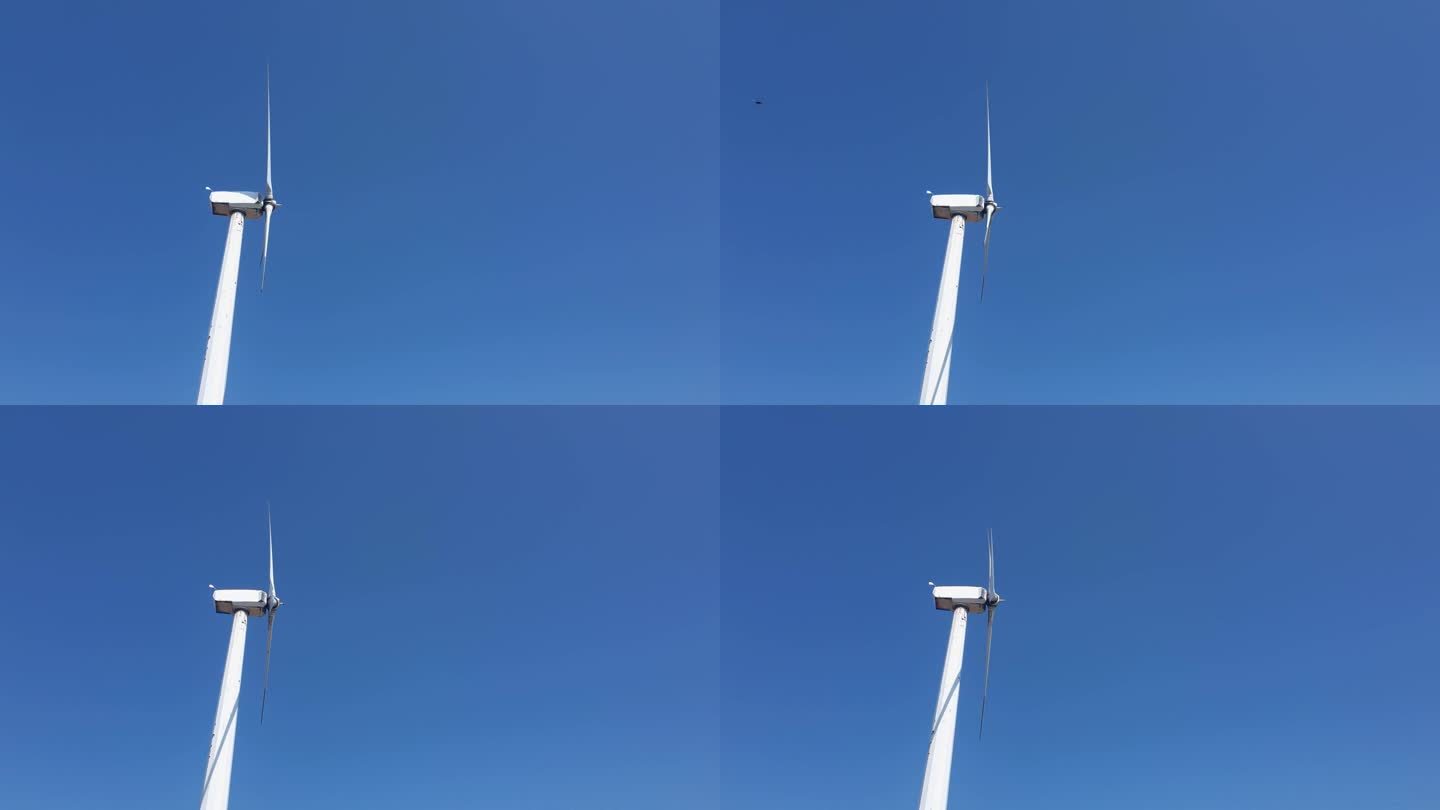 风力涡轮机的转子在蓝天的映衬下快速旋转。