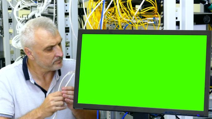 维护工程师在服务器室连接网线(绿屏)