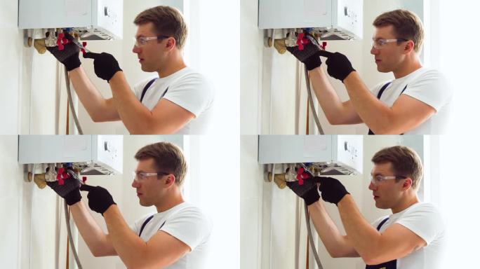 水管工在安装锅炉或热水器时使用扳手的特写，在公寓供暖系统工作
