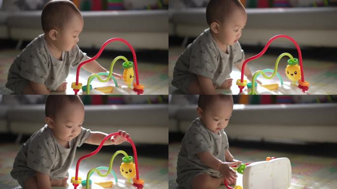 8个月大的小男孩在家里开心地玩着五颜六色的玩具