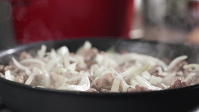 慢镜头的猪肉与洋葱煎锅烹饪肉饭