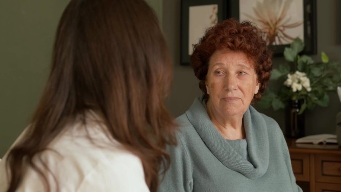 主治医生向一位老年女病人介绍治疗和保健方法。老妇人认真倾听