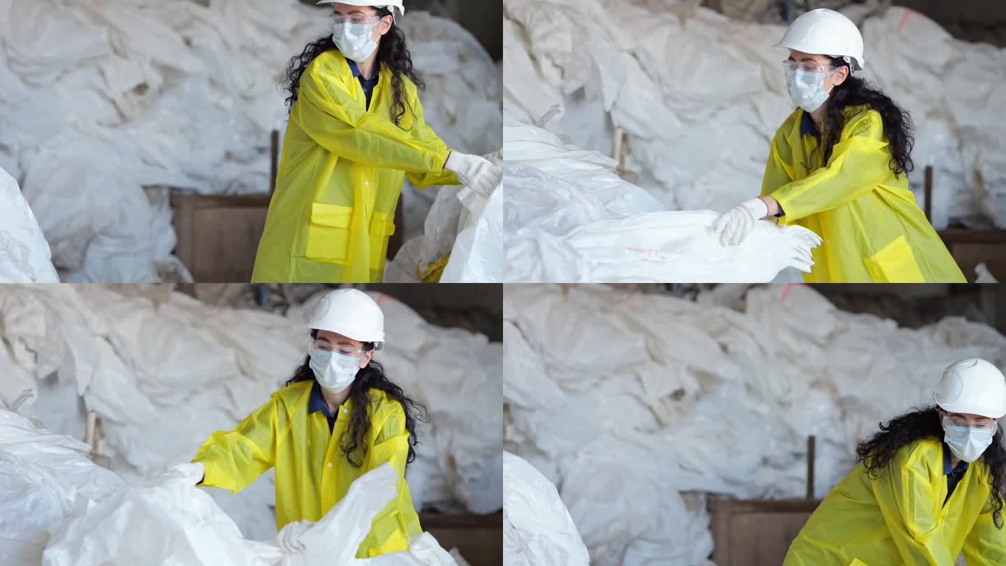 戴口罩的黑头发女工在垃圾处理厂拣垃圾