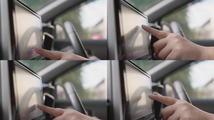 一个人触摸汽车仪表盘的多媒体触摸屏来查看地图gps或控制音乐收音机准备开车