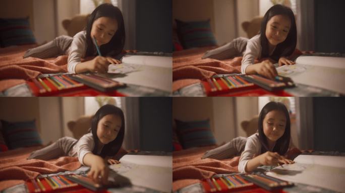 可爱的韩国小女孩用彩色铅笔给孩子画全家福。小孩子躺在床上，用不同的铅笔为她的父母做一件艺术品
