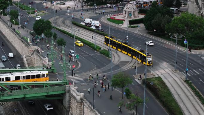 城市交通鸟瞰图。汽车和电车穿过城市的十字路口。行人和骑自行车的人过马路。匈牙利布达佩斯