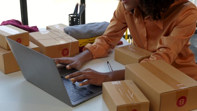 美丽的非裔美国女性开始做小生意。一名妇女在家工作，在网上投递包裹。企业家，中小企业交付理念。
