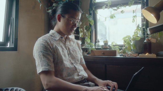 亚洲人在古董店摆弄笔记本电脑