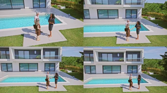 女房地产经纪人站在后院的游泳池边和一对夫妇握手