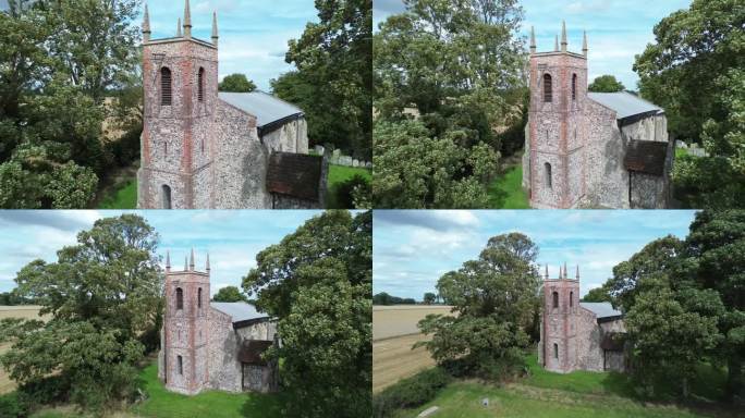 无人机拍摄的老教堂之间的树木在农村地区与多云的天空背景