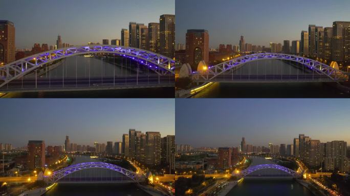 夜色中，以城市景观为背景的水上灯光桥的无人机视图