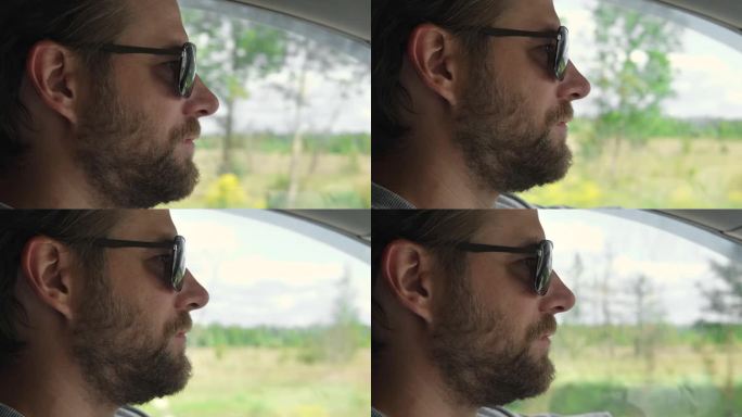 自信的大胡子男子戴着墨镜在旅途中开车。车内乘客的侧视图。夏天的一天。手放在方向盘上。司机目不转睛地盯