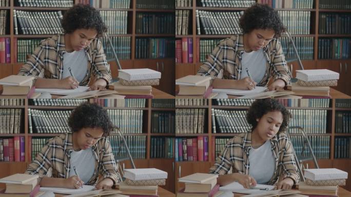 疲惫的非裔美国妇女在图书馆准备考试，读书，写作，感到压力的肖像