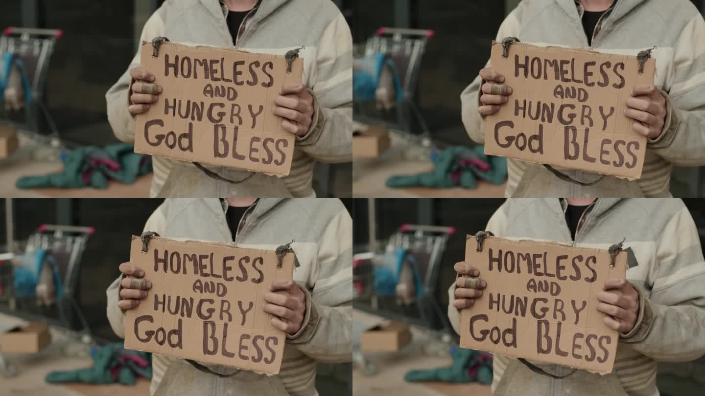 站在标牌旁的男流浪汉无家可归，饥肠辘辘