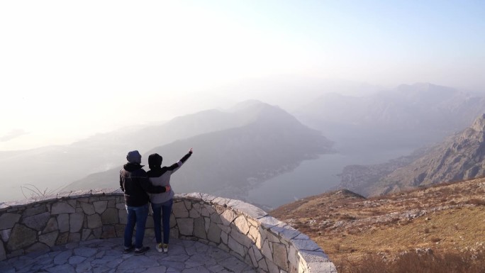 男人和女人拥抱在观景台上看山