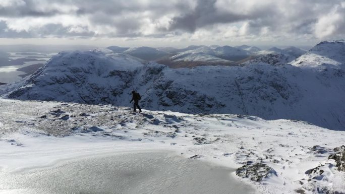 徒步旅行者登上苏格兰一座雄伟山脉的顶峰。
从洛蒙德湖的Ban Vane鸟瞰苏格兰高地的雪山。高山的观