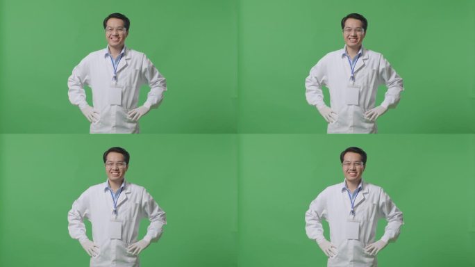 亚洲男性科学家两手叉腰站在实验室的绿幕背景上，微笑着看着镜头