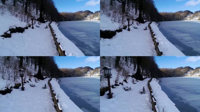 冰雪覆盖的人行道紧挨着结冰的湖