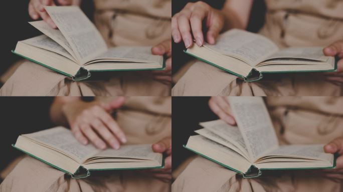 一个穿着古装的女孩在家里读一本古书。女性的手在翻动书页。关闭了。女人在看书。