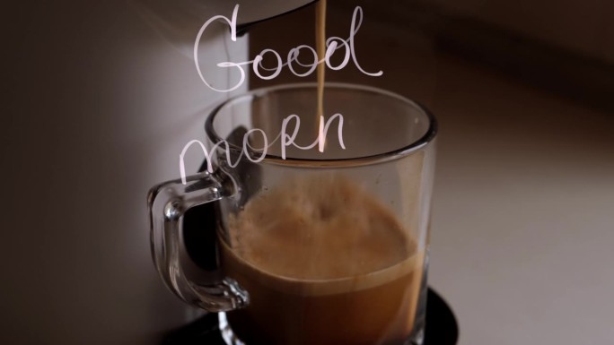准备咖啡流从白色咖啡机或咖啡机倒入透明的马克杯，在浅色背景上有手写的早上好祝福