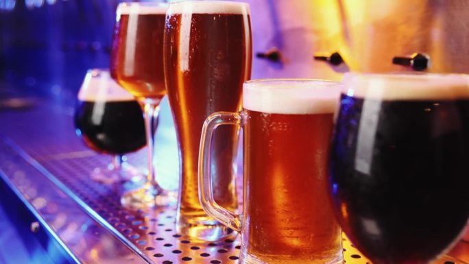 深色啤酒和窖藏啤酒的啤酒杯特写图片。有选择性的重点。清凉的饮料。茶点。酒吧，酒吧氛围
