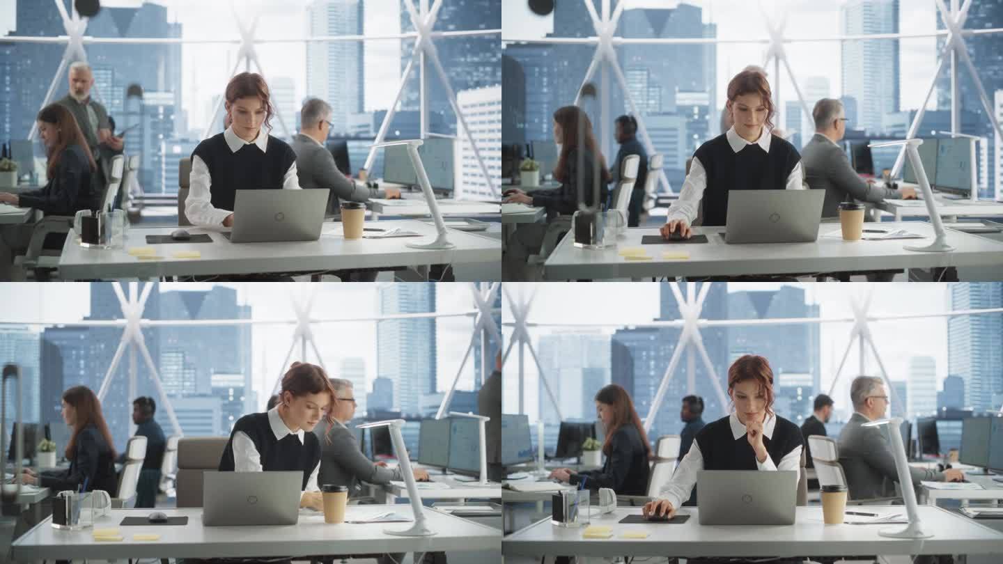 美丽的白人女性在市区摩天大楼明亮的办公室里用笔记本电脑工作。女性业务发展经理在工作空间与不同的同事写