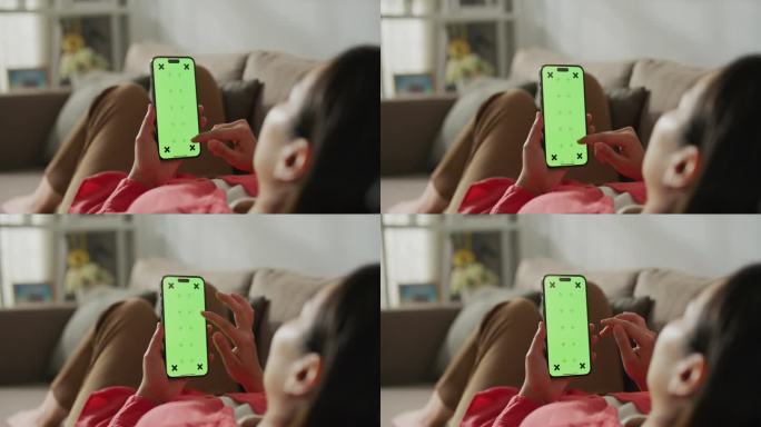 女子使用绿色屏幕的智能手机