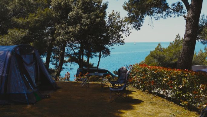 夏天在海边露营。阳光明媚的日子里，帐篷外的空椅子